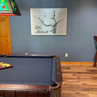 Custom metal Lake Harwell map wall art above a pool table in a room.