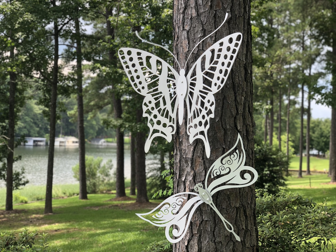 a metal butterfly and dragonfly on a tree