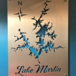 Lake Martin metal map with compass rose, mounted on a blue wall.