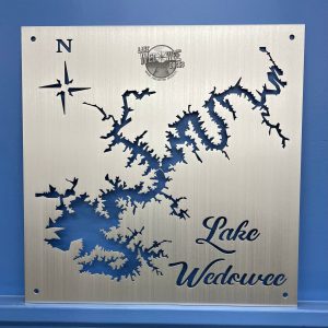 Lake Wedowee metal map with compass rose and "Lake Wedowee Docks" logo on brushed silver, mounted on a blue wall.