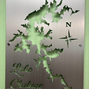 Lake Chatuge map cutout on brushed metal with compass rose, mounted on green wall.