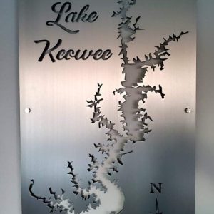 Lake Keowee metal map sign with intricate cutout design and compass rose on a brushed metallic surface.