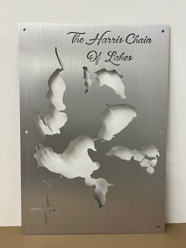 The Harris Chain of Lakes metal map with compass rose on brushed silver finish.