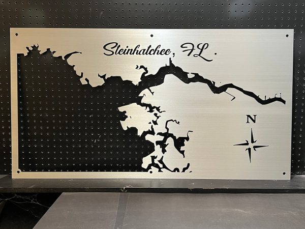 Steinhatchee, FL metal map with compass rose, featuring intricate cutout design on a black pegboard background.