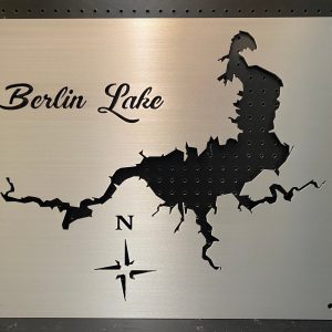 Berlin Lake metal map with cutout design and compass rose on a brushed background.