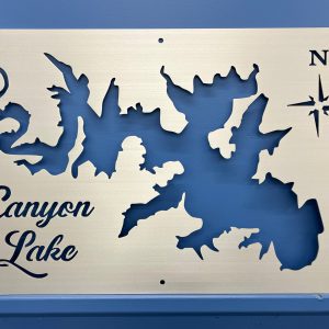 Custom metal map of Canyon Lake with cutout design and compass rose on a blue wall.