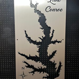 Lake Conroe map cutout on brushed metal with decorative script and compass rose, set against a perforated background.