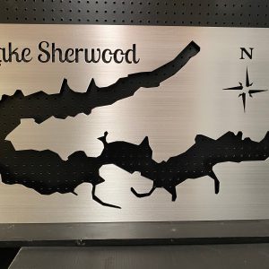 Lake Sherwood metal map with compass rose, cutout design on a brushed silver background, mounted on a black pegboard.