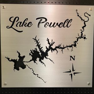 Lake Powell metal map with compass rose on a brushed silver background, mounted on a black pegboard.