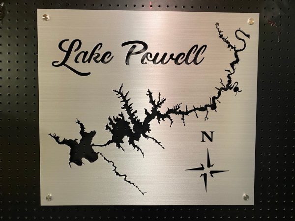 Lake Powell metal map with compass rose on a brushed silver background, mounted on a black pegboard.