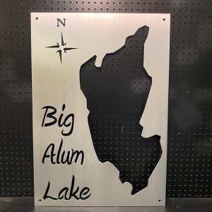 Big Alum Lake metal map with compass rose on a perforated black background.