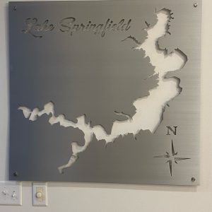 Lake Springfield metal map with compass rose cutout, mounted on a light wall.