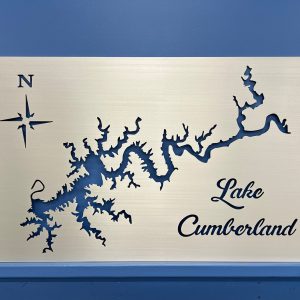 Lake Cumberland map on brushed metal with decorative script and compass rose, set against a blue wall.