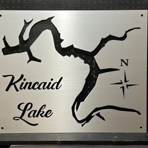 Kincaid Lake metal map with compass rose on brushed metallic background, mounted on a perforated black wall.