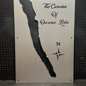 Owasco Lake metal map with "The Curvins of Owasco Lake" text and compass rose, mounted on a black pegboard.