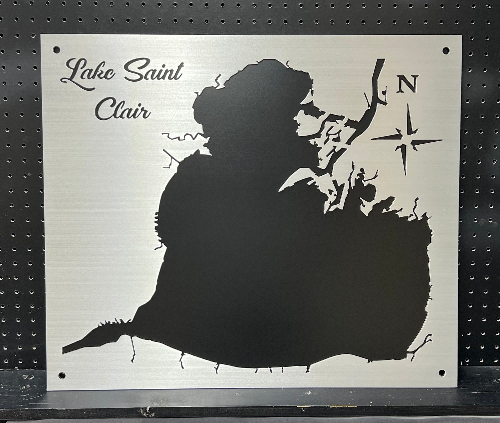 Lake Saint Clair custom metal map with compass rose on a brushed silver background, mounted on a black pegboard.