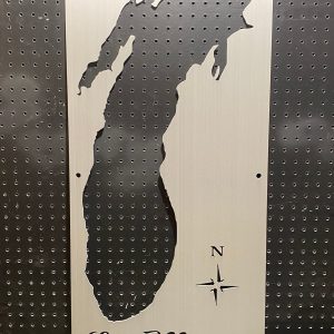 Lake Michigan cutout metal sign with compass rose on perforated black background.