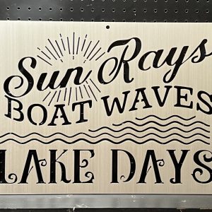 "Sun Rays, Boat Waves, Lake Days" text on brushed metal sign with wave and sunbeam design against perforated background.