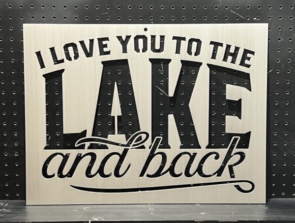 Metal sign with "I Love You to the Lake and Back" text cutout on a perforated background.