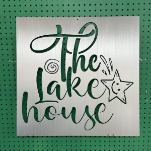 Metal sign with "The Lake House" text and star design on a green pegboard background.