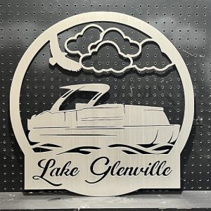 Lake Glenville metal sign with a pontoon design and cloud motif, mounted on a black pegboard background.