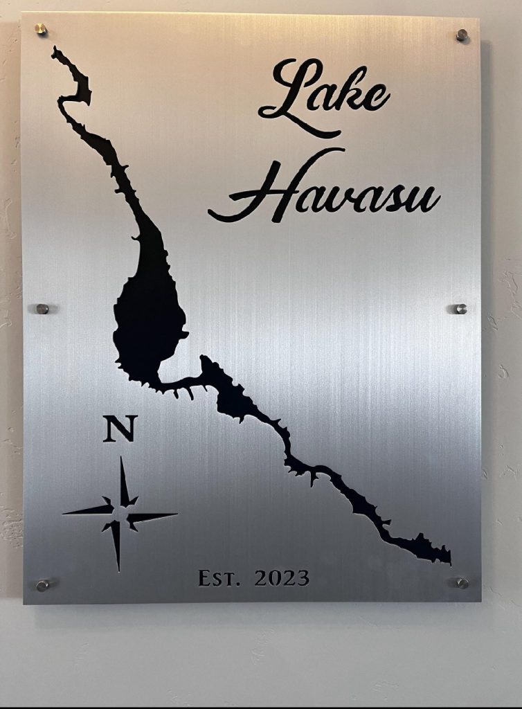 Lake Havasu metal sign with lake outline, compass rose, and "Est. 2023" on brushed metallic background.