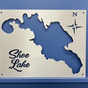 Shoe Lake metal map with compass rose on a blue wall background.