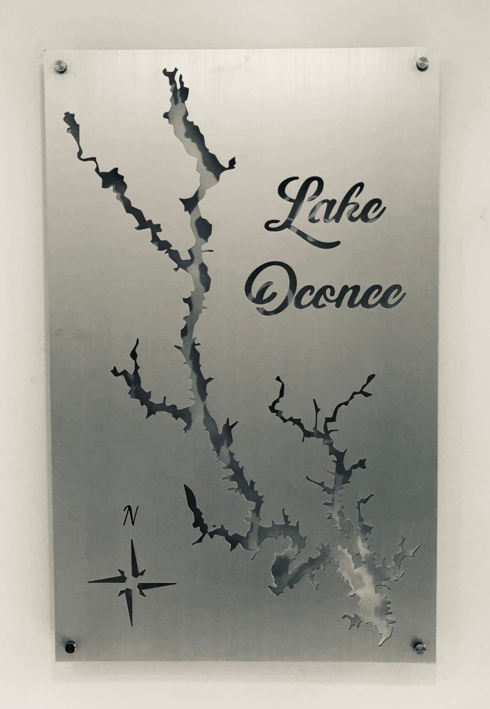 Lake Oconee metal map with cutout detailing and compass rose on a brushed silver background.