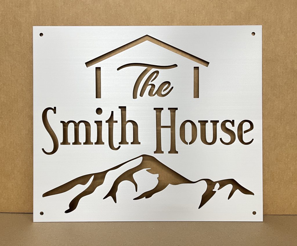 Custom metal sign with "The Smith House" text and mountain design, on a light brown background.