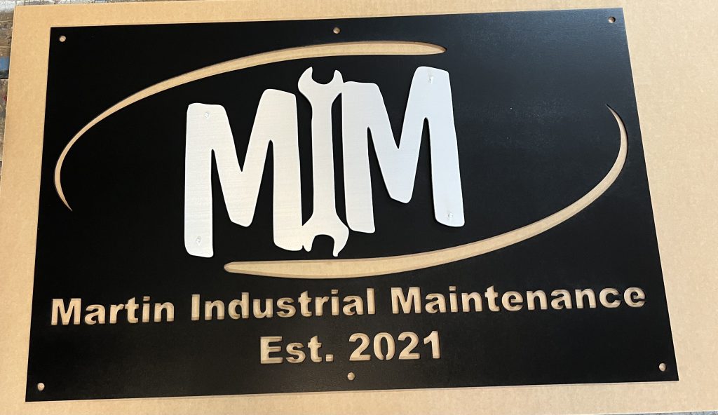 Metal sign with "Martin Industrial Maintenance" and wrench logo, Est. 2021, on a black background.