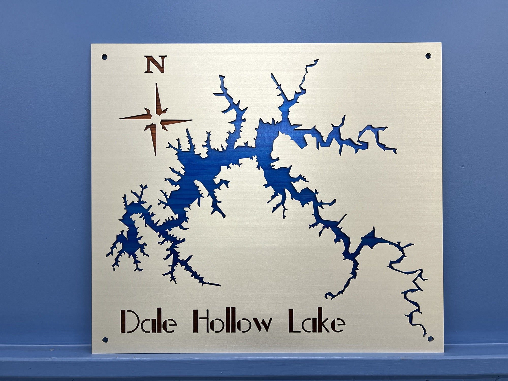 Metal map of Dale Hollow Lake with compass design, mounted on a blue wall.