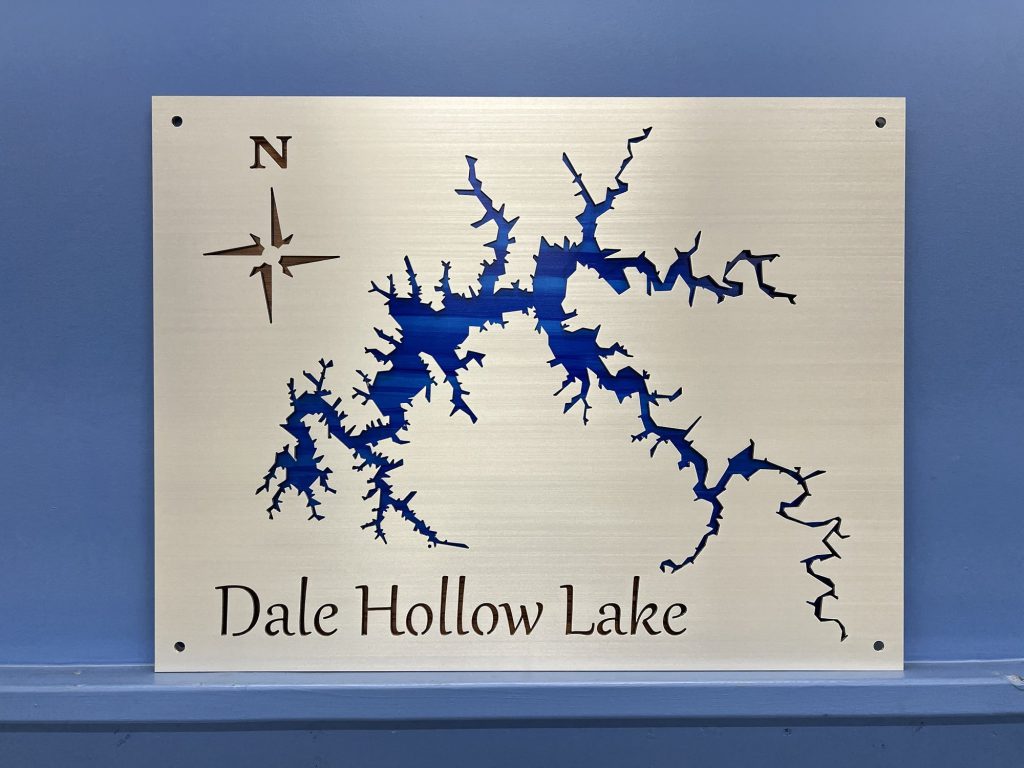 Custom metal map of Dale Hollow Lake with compass rose on a polished background, mounted on a blue wall.