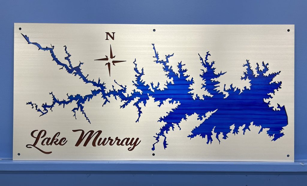 Lake Murray metal map with blue cutout design and compass rose, mounted on a blue wall.