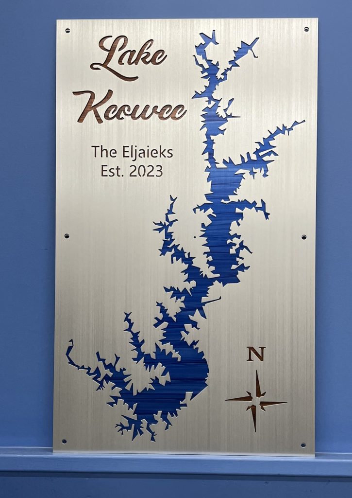 Lake Keowee custom sign with blue map cutout, "The Eljaieks Est. 2023," and compass rose on a metallic background.