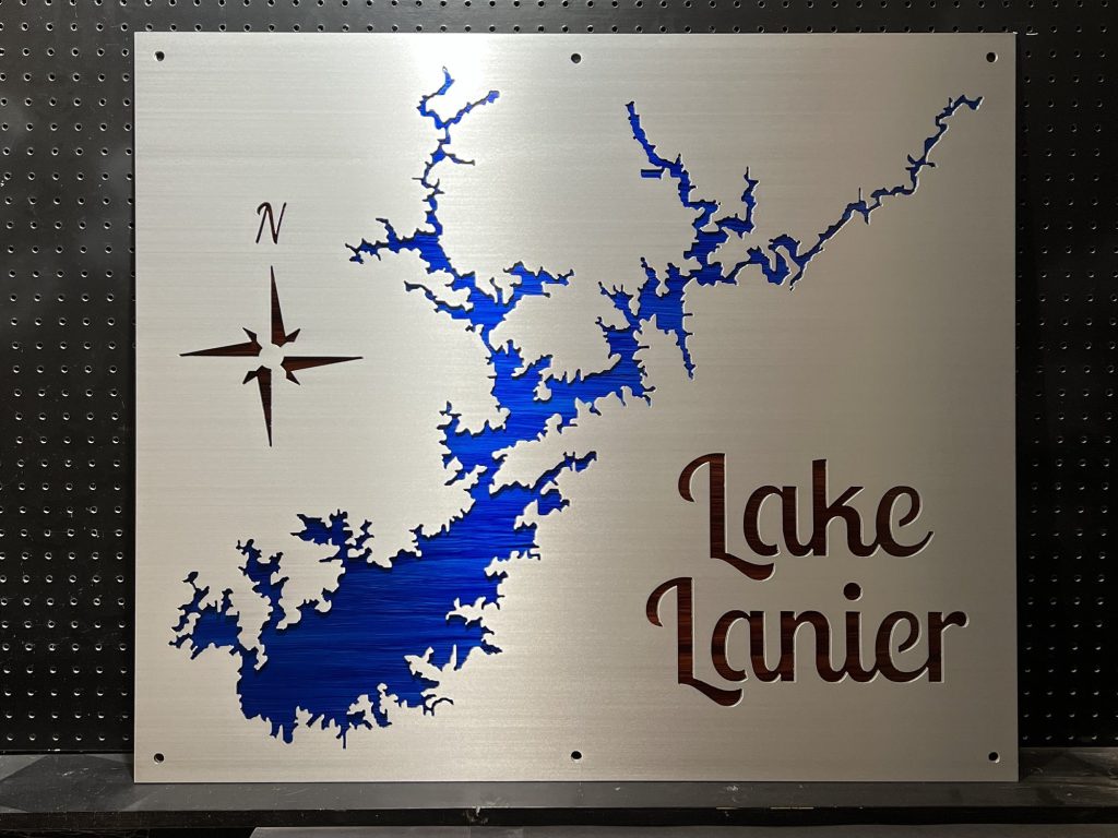 Lake Lanier metal map with blue detail and compass rose, mounted on a perforated black background.