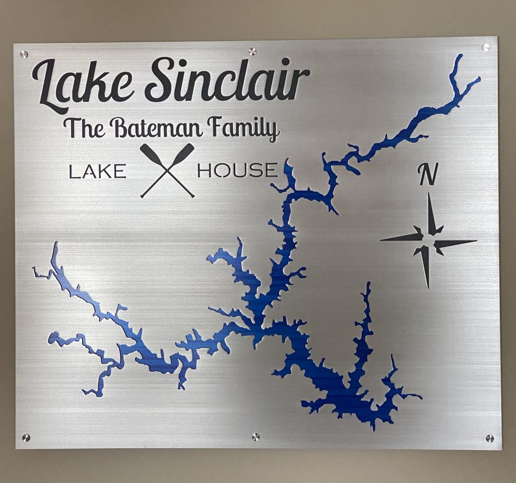 Lake Sinclair metal map sign, "The Bateman Family Lake House" with crossed paddles and compass rose on brushed silver.