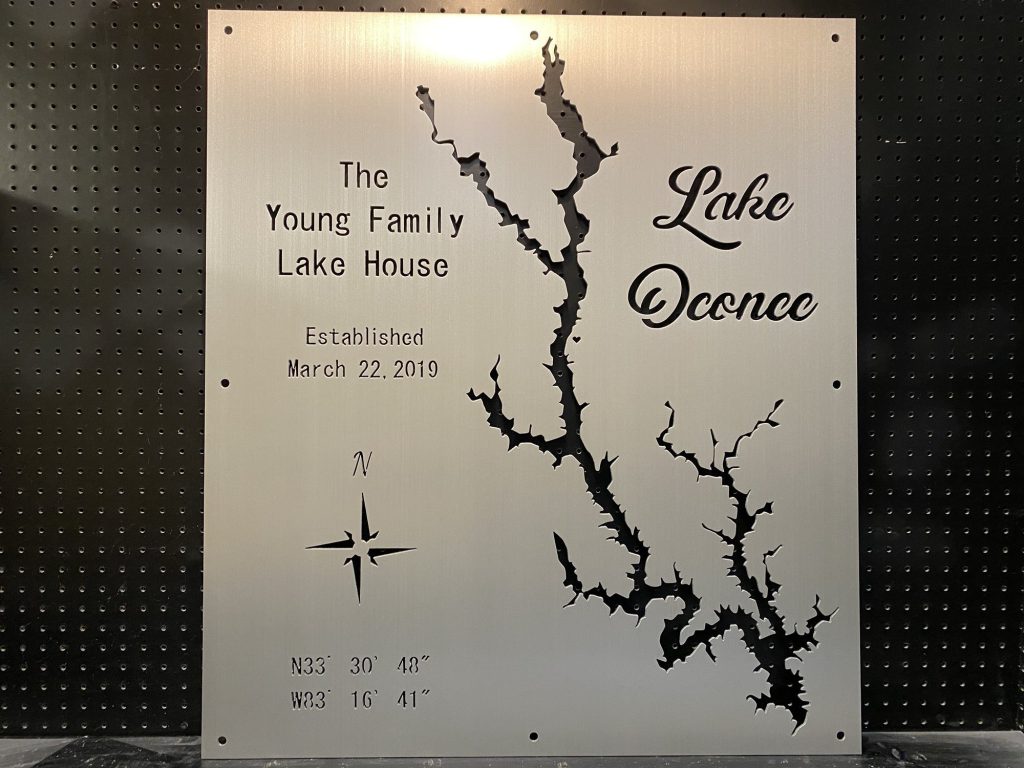 Lake Oconee metal map sign for "The Young Family Lake House," established March 22, 2019, with coordinates and compass rose.