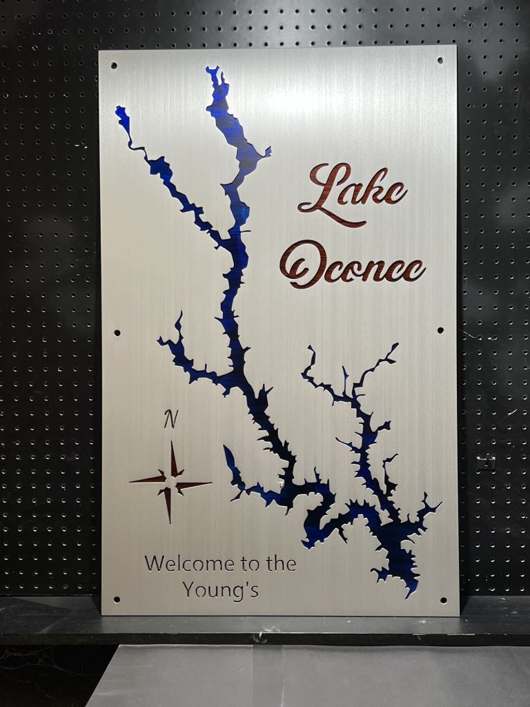 Lake Oconee metal map with blue cutout, compass rose, and "Welcome to the Young's" text on a brushed silver background.