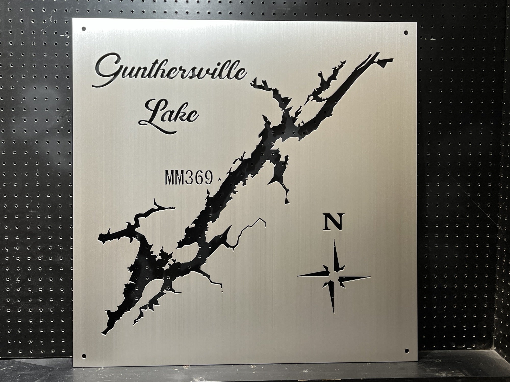 Guntersville Lake metal map with compass design and "MM369" text on a perforated black background.