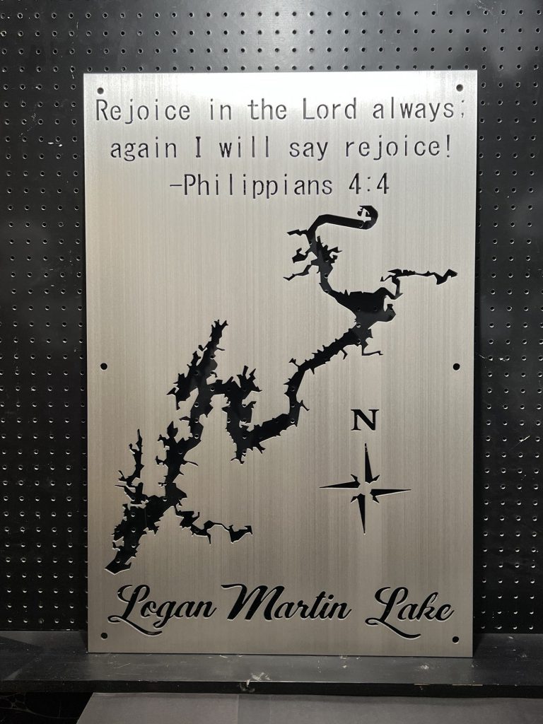 Logan Martin Lake metal map with Philippians 4:4 verse on brushed silver, featuring a compass rose on a black pegboard.