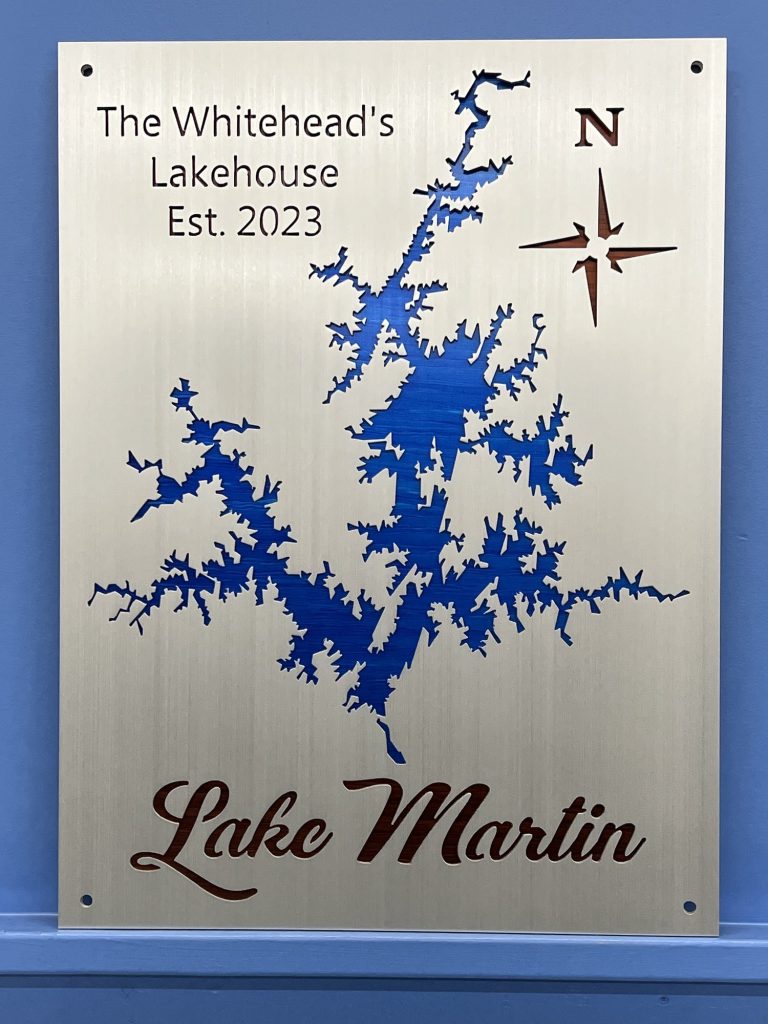 Lake Martin metal sign for The Whitehead's Lakehouse, Est. 2023, with compass rose on a blue wall.